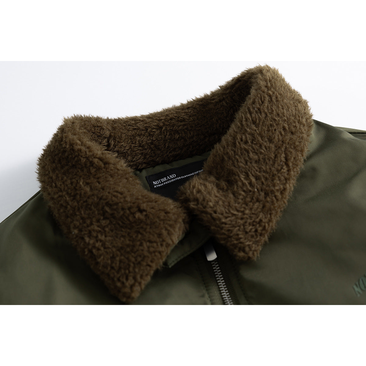 Close-up of an olive bomber jacket with a thick brown plush collar, front zipper, and visible neck label.