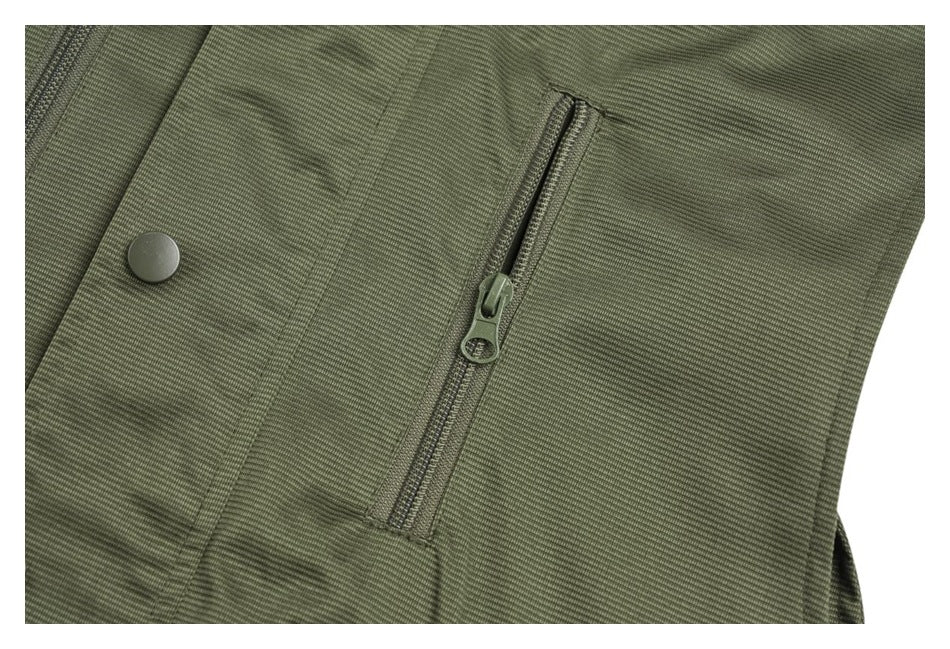 Close-up of a vertical zip pocket and snap fastener on the olive-green vest.