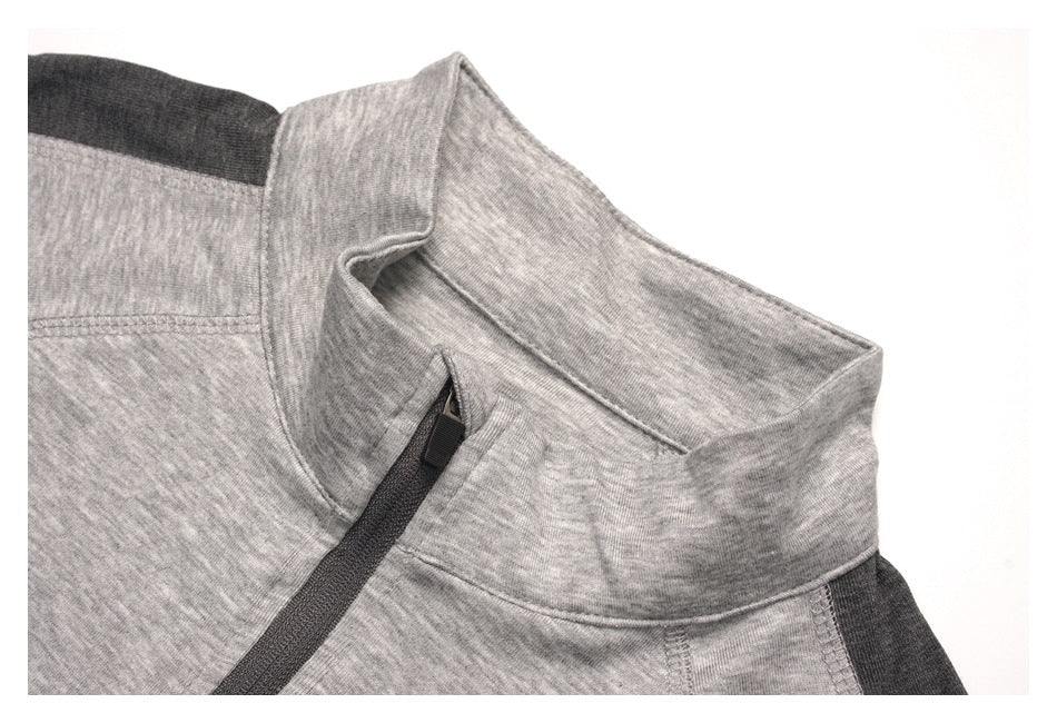Close-up of a light gray heather stand collar, dark contrast panels, and a diagonal dark zipper.