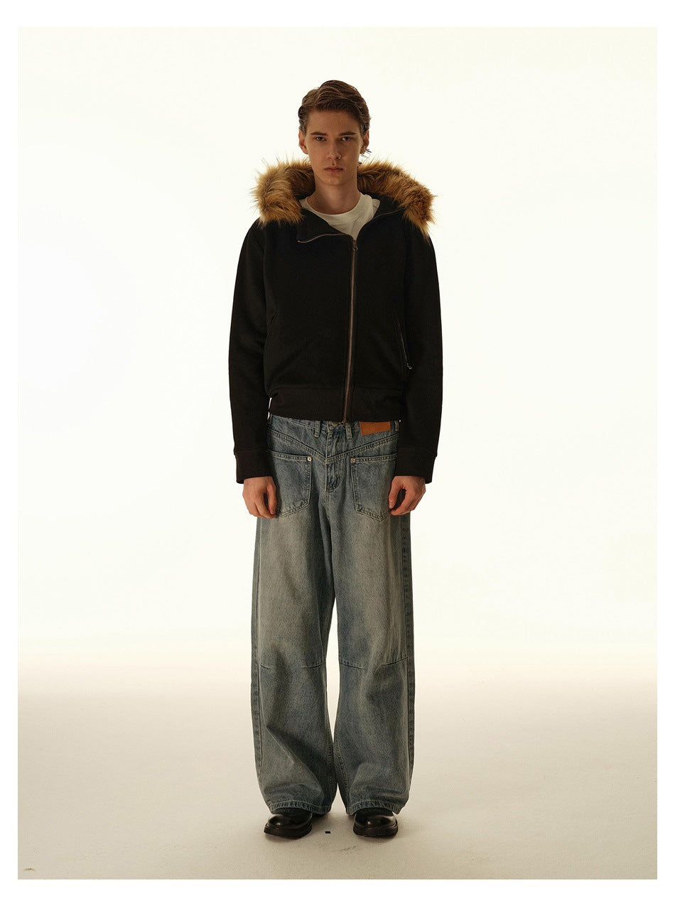 Full-length view of a man wearing a black fur-trimmed hooded jacket, loose blue jeans, and black shoes.