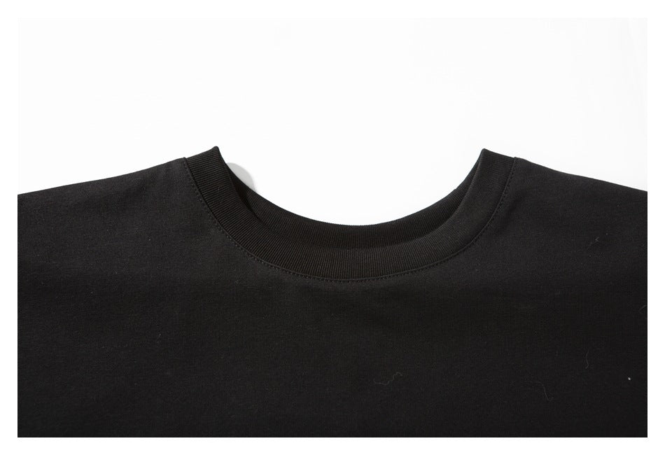 Close-up of the ribbed crew neckline and upper chest of a plain black T-shirt.