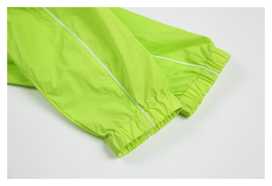 Close-up of neon lime garment cuffs with elastic gathers and white piping.