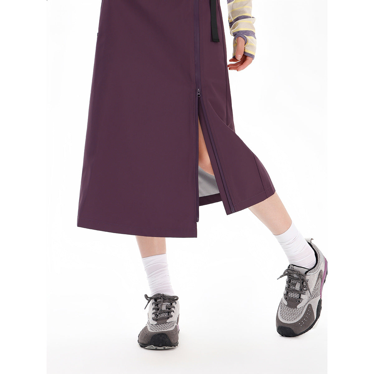 Close view of a plum midi skirt worn with its side zipper partly open to form a slit.