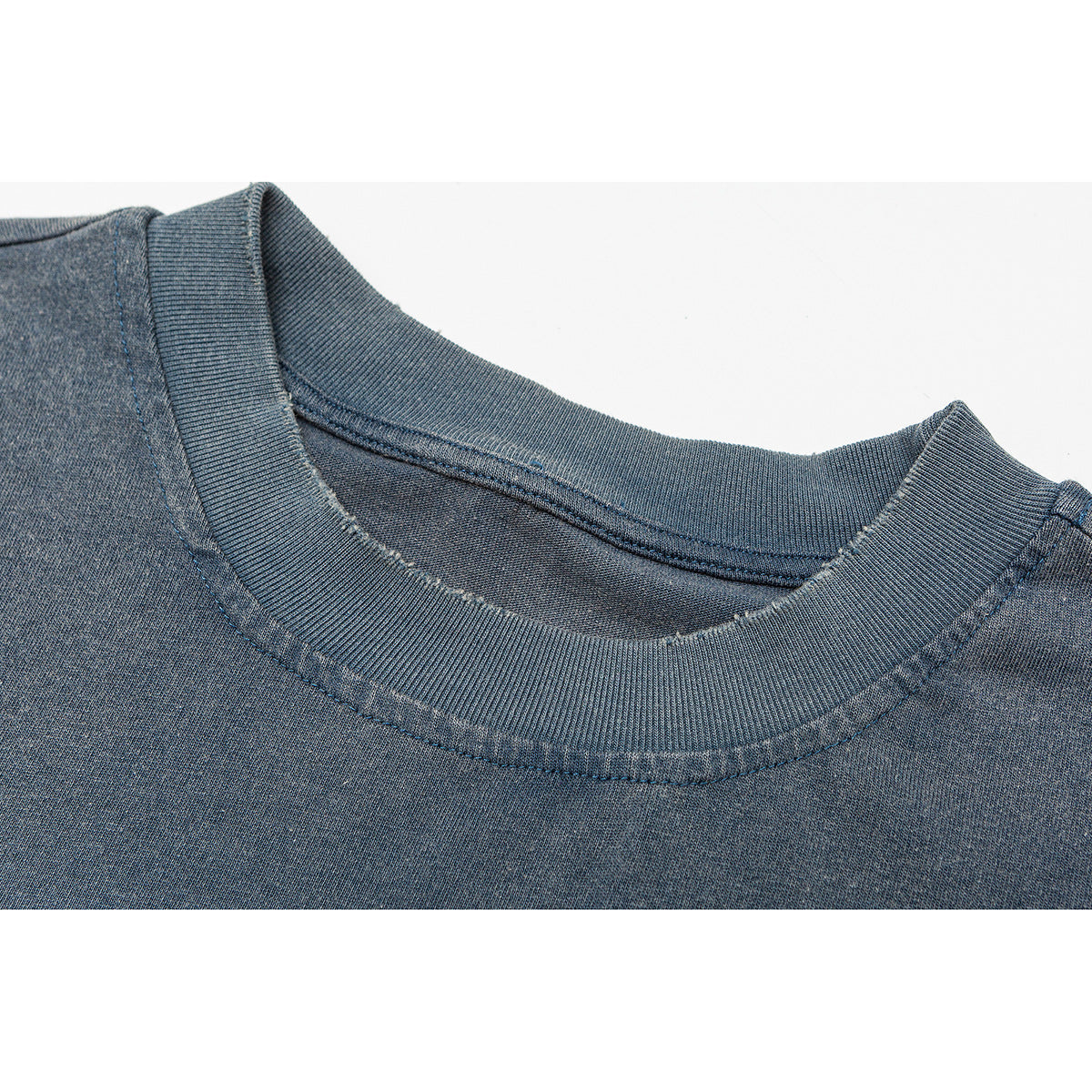 Close-up of the ribbed crew neckline and stitching on a faded blue T-shirt.