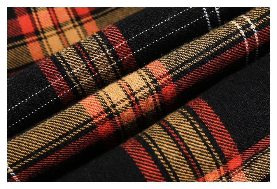 Macro view of the black, red and tan plaid fabric and its woven texture.
