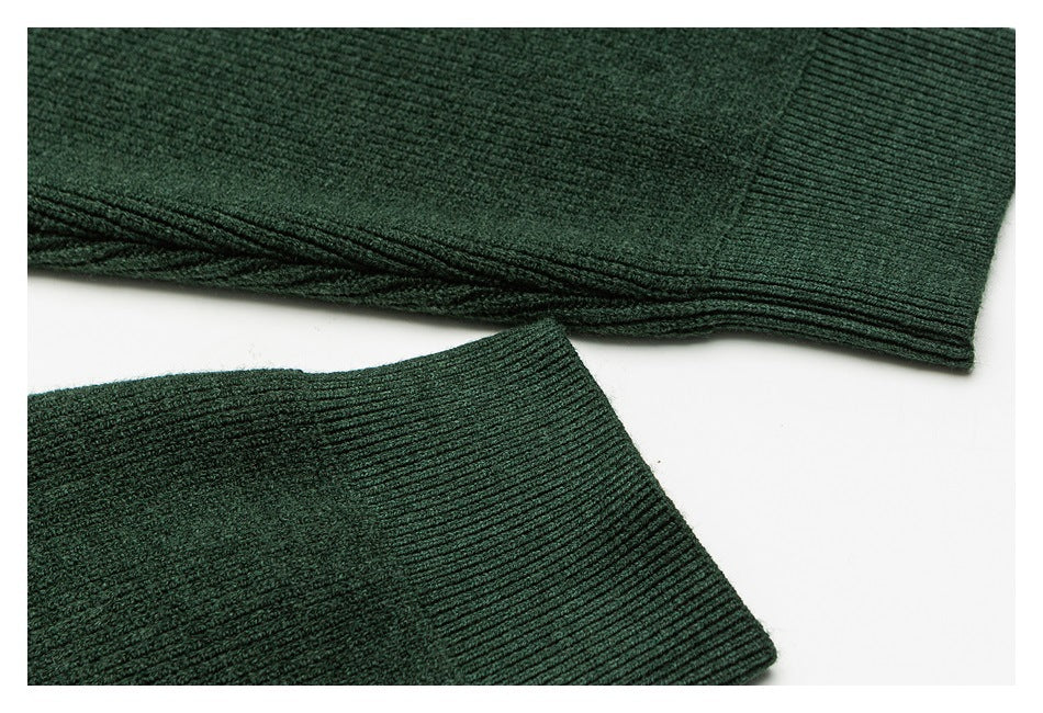 Close-up of dark green rib-knit sleeve ends laid flat on a white background.