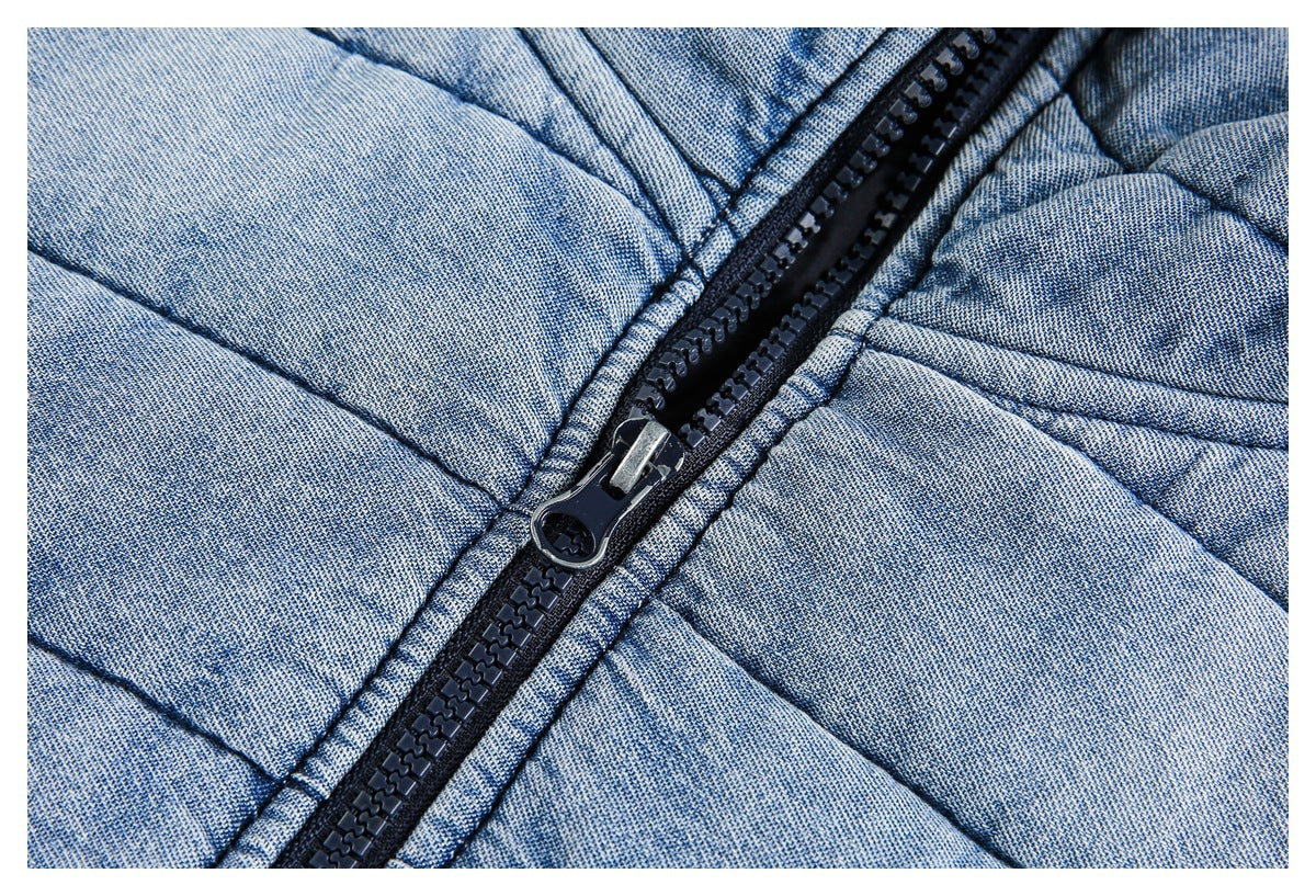 Close-up of the black zipper and quilted light blue fabric on a jacket.