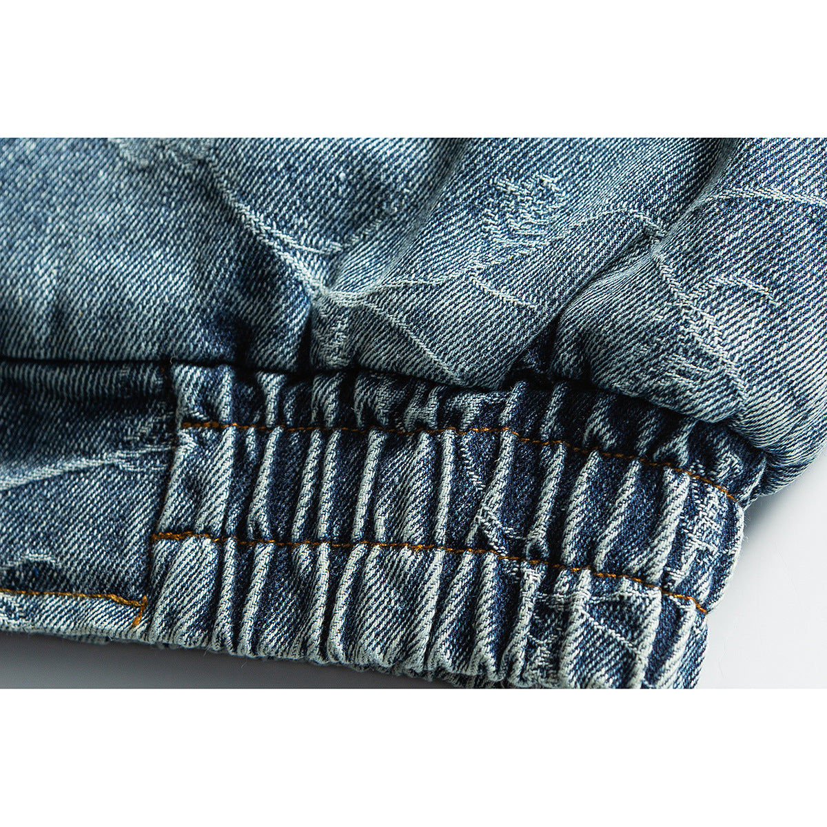 Close-up of the jacket's gathered elastic denim hem and contrast stitching.
