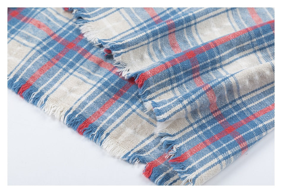 Close-up of the shirt's blue, red, and cream plaid fabric and intentionally frayed edges.