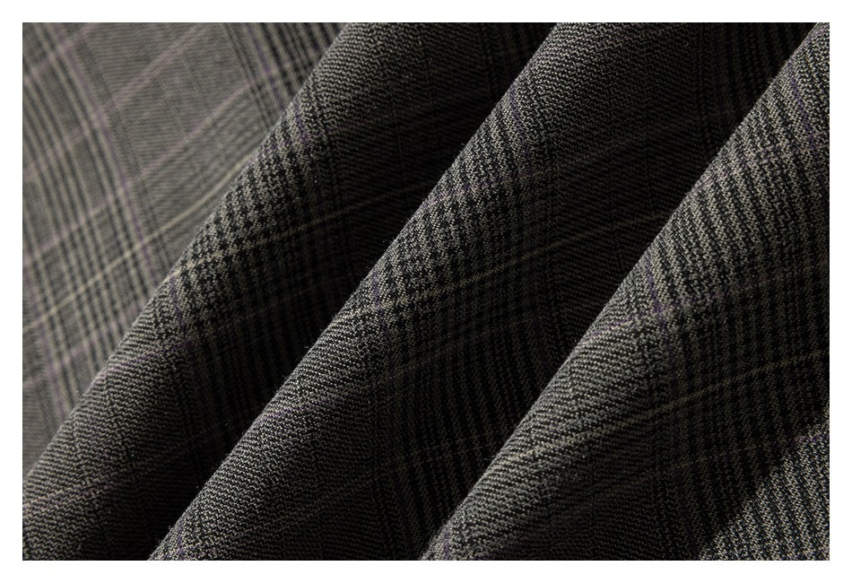 Close-up of folded dark gray plaid fabric showing its fine woven pattern.