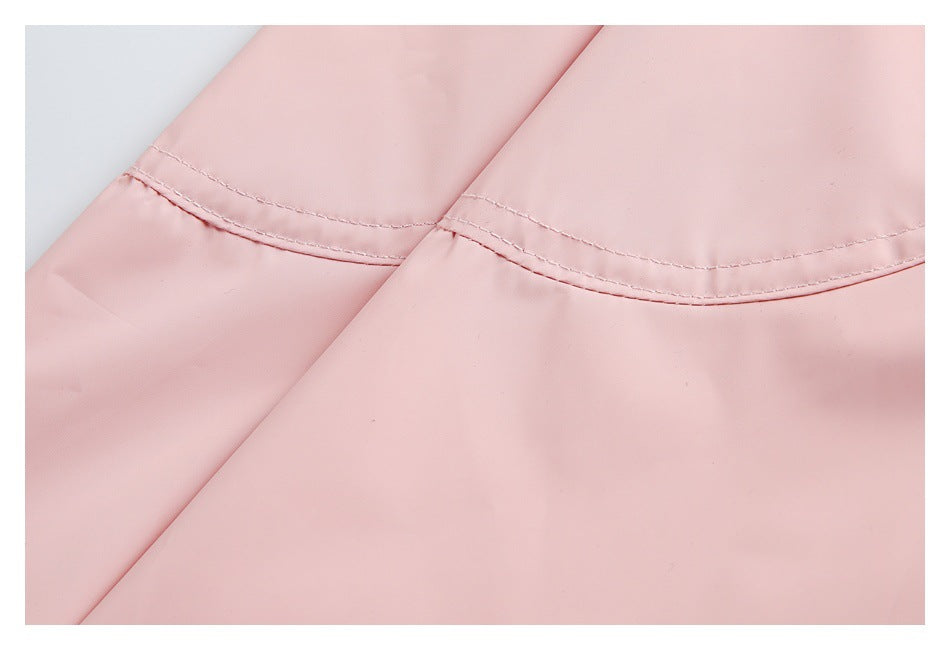 Close-up of curved double-stitched seams across pale pink garment panels.