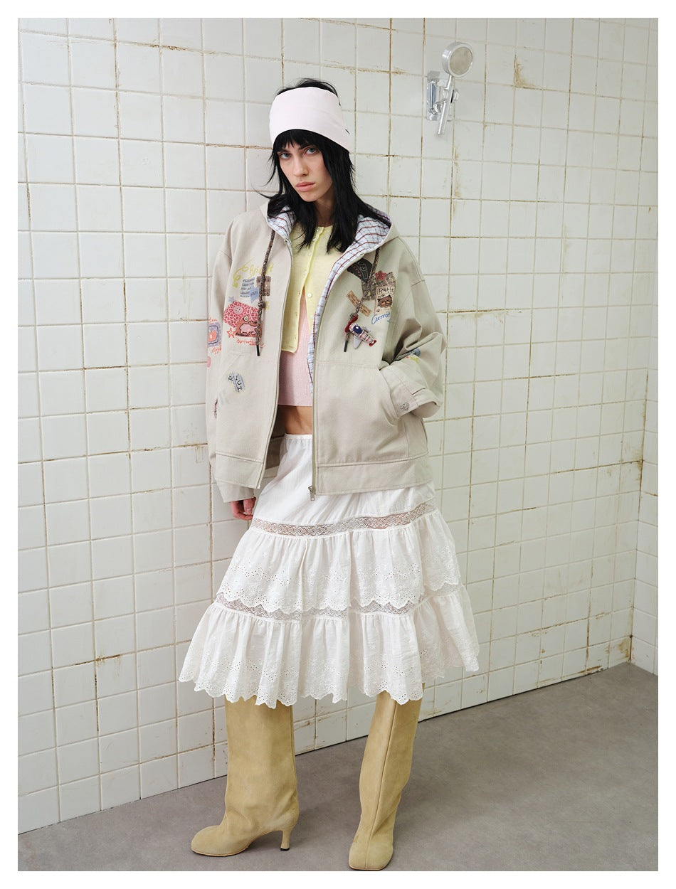 Full-length view of model wearing beige hooded patchwork jacket with white tiered skirt and tan boots