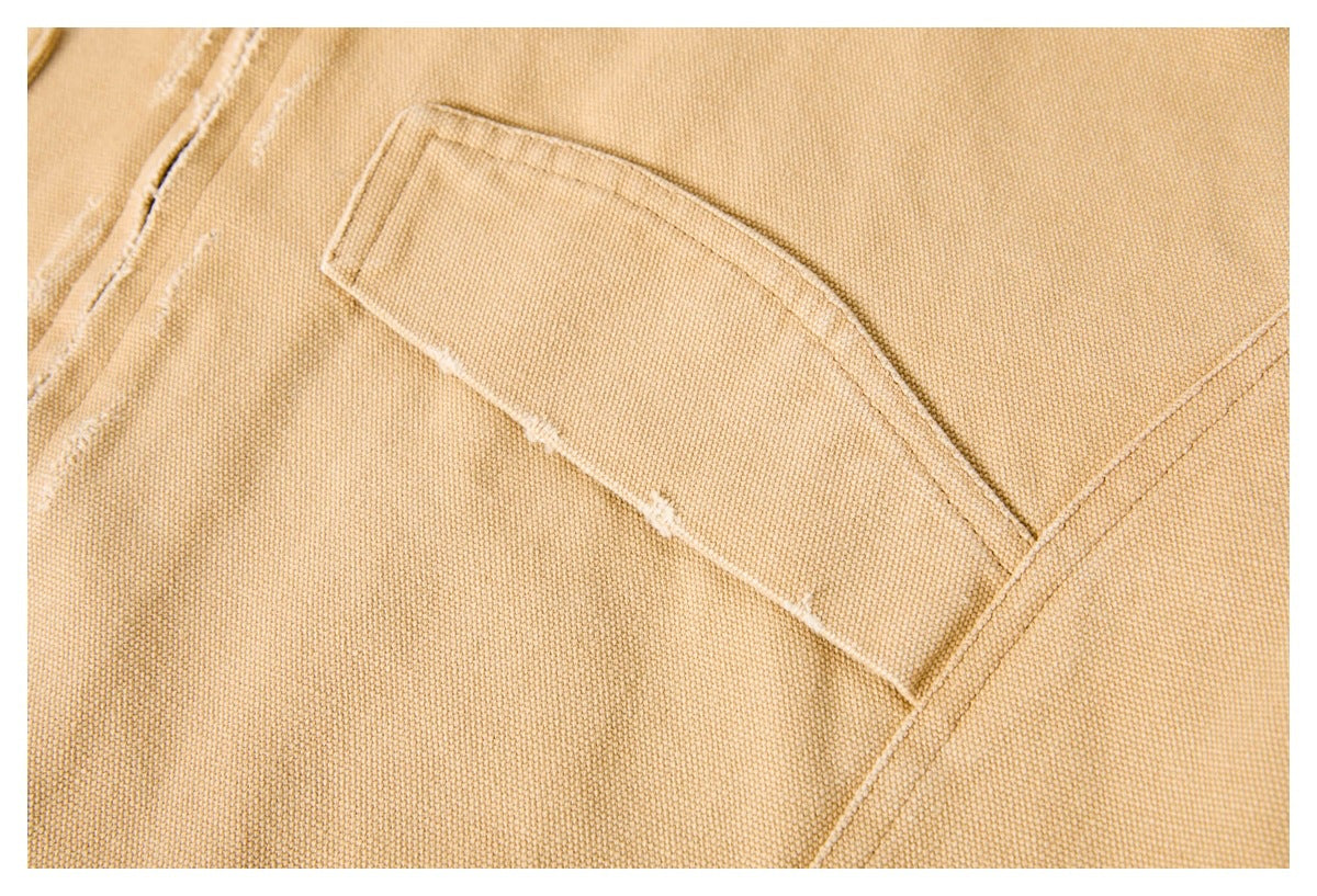 Close-up of a tan woven garment with a large angled stitched pocket.