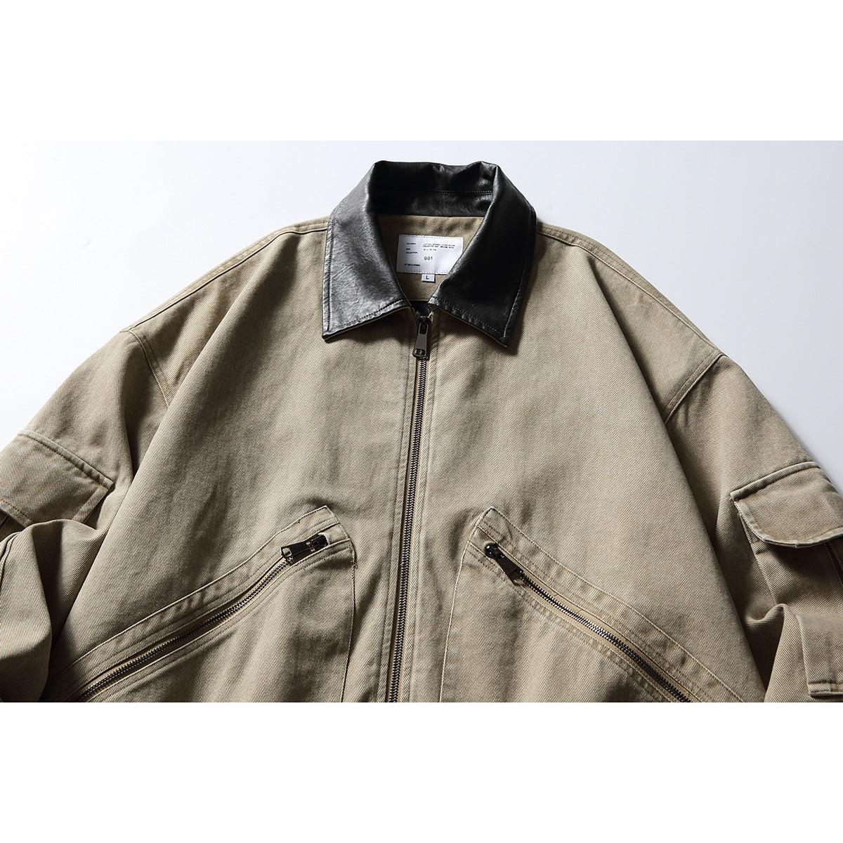 Front view of a taupe zip-front jacket with a black collar, angled zip pockets, and flap sleeve pockets.