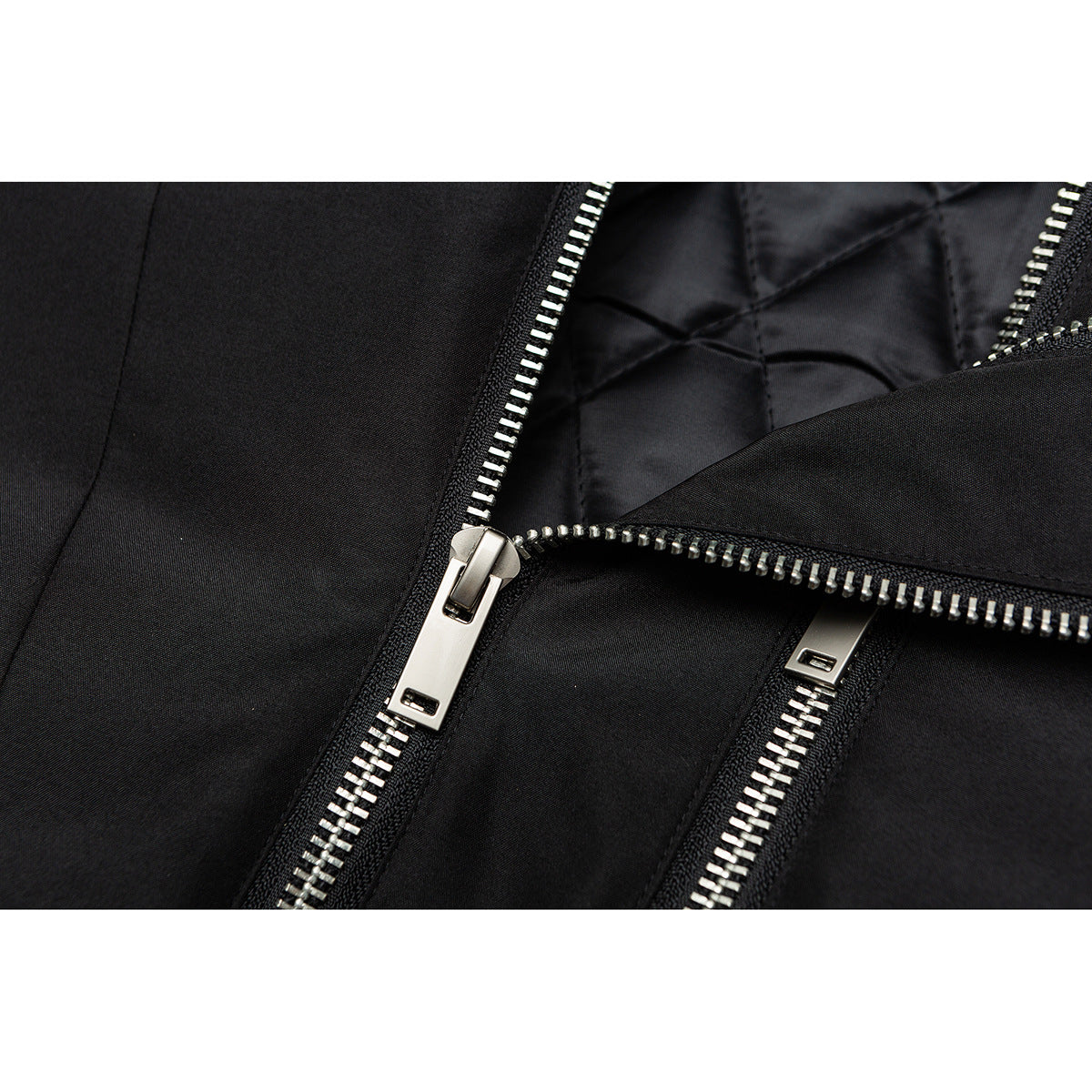 Close-up of the black jacket's silver double zippers and quilted lining.