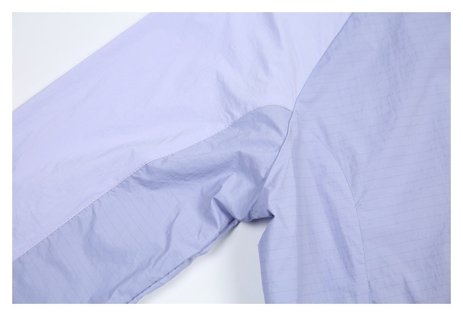 Close-up of a lavender jacket sleeve and body seam, with subtle grid-textured panels.
