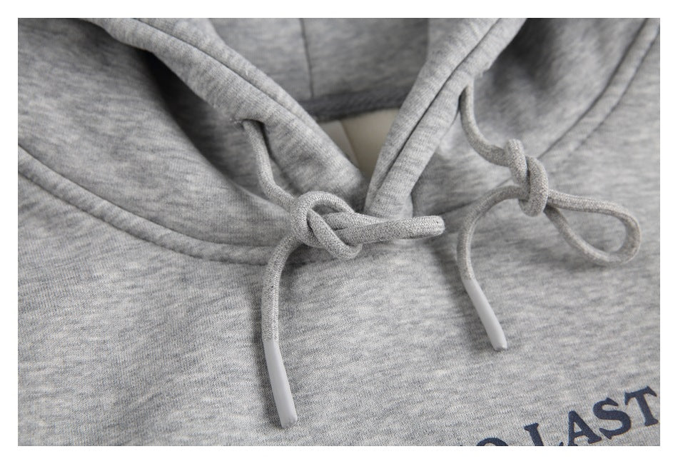Close-up of the heather-gray hoodie’s tied drawstrings and hood opening.