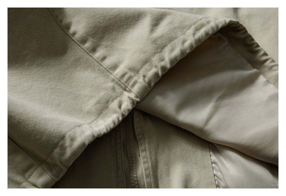 Close-up showing the light khaki jacket's hood edge, smooth lining, and zipper beneath.