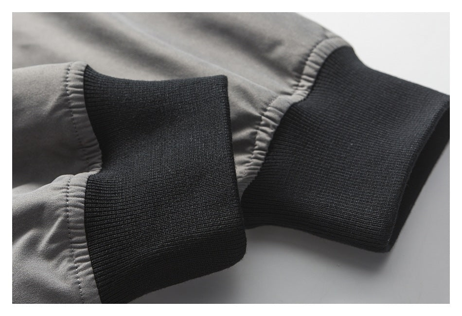 Close-up of a gray jacket sleeve with a wide black rib-knit cuff.