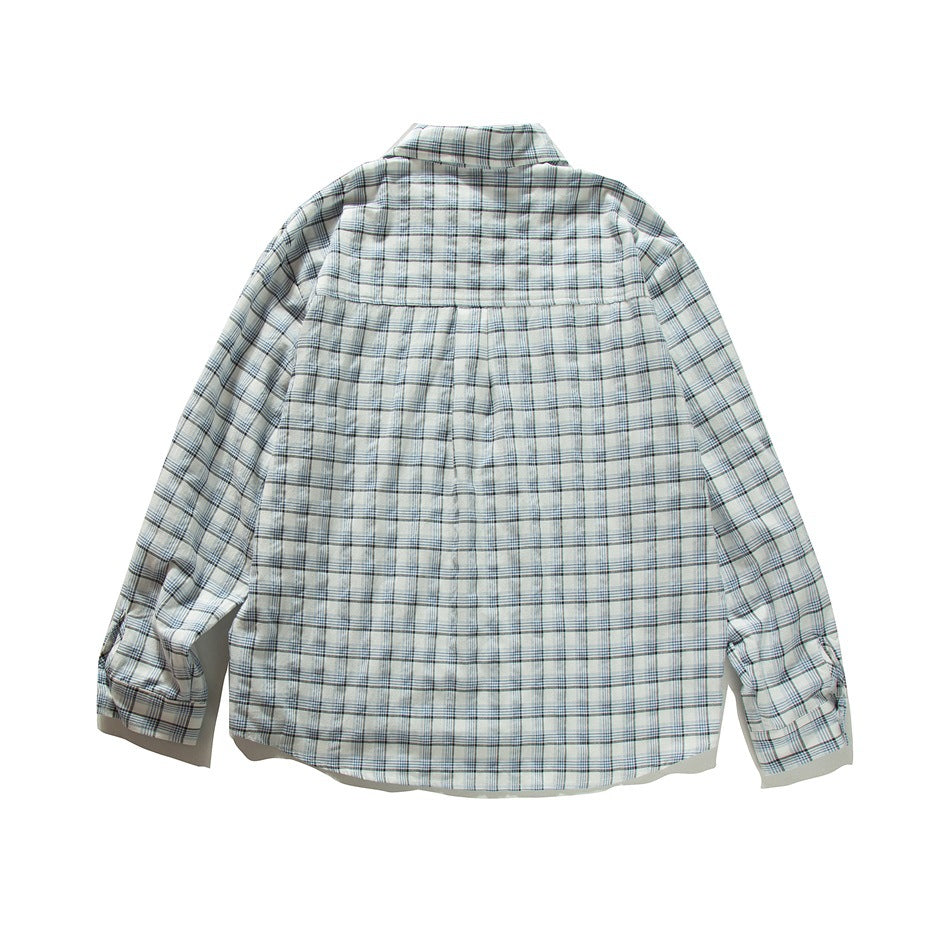 Back view of blue and white plaid long-sleeve shirt laid flat, showing back yoke and center pleat