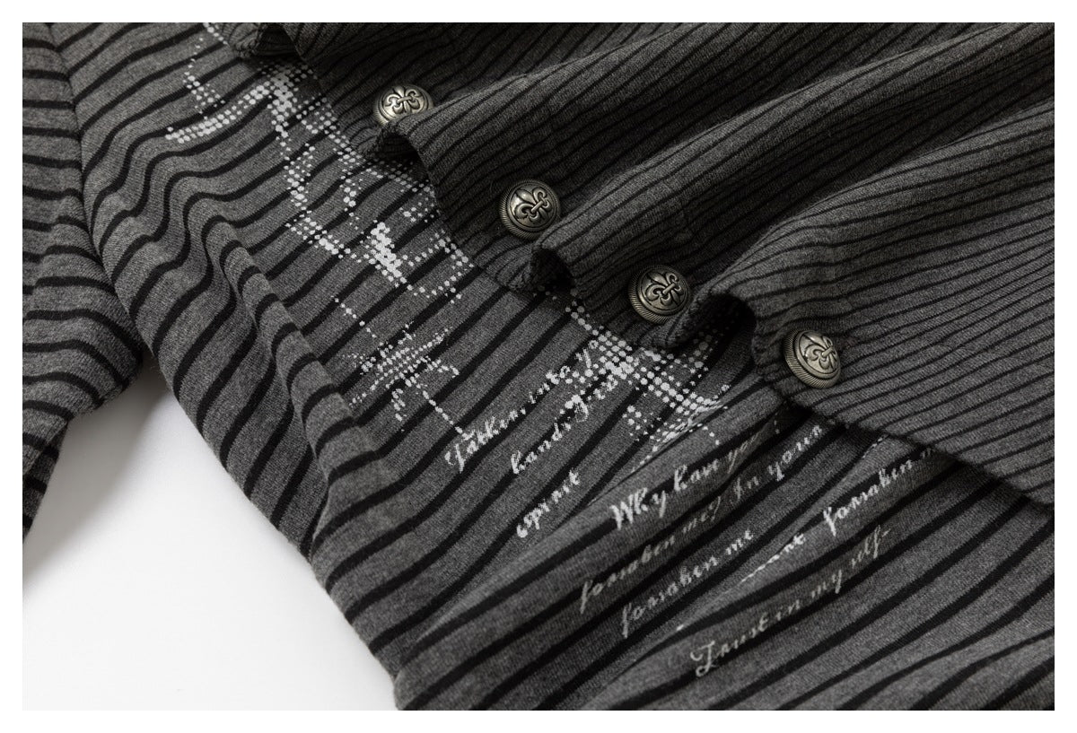 Close-up of a charcoal striped top showing ornate front buttons and pale script printed across the fabric.