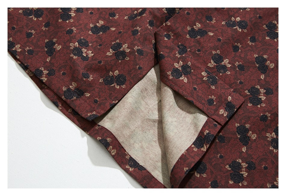 Close-up of a reddish-brown floral garment opened to show its light-colored reverse side and seam.