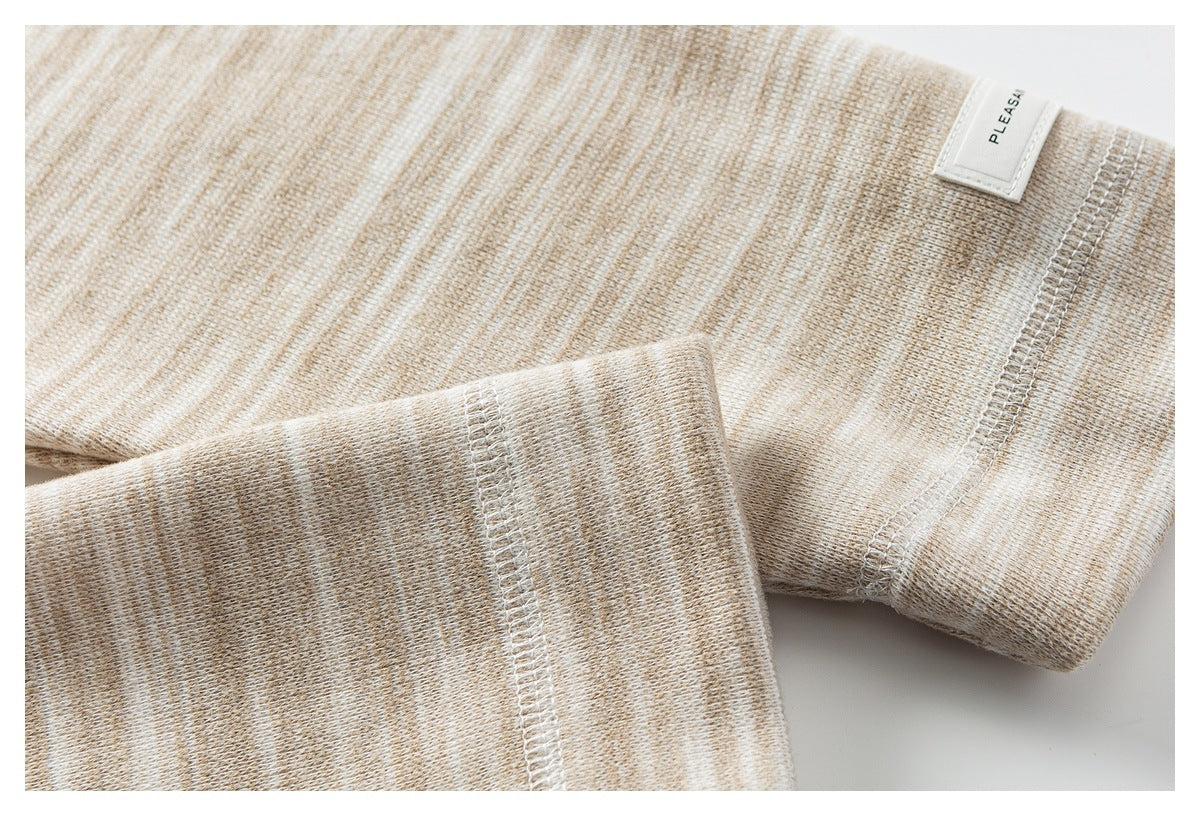 Close-up of a beige heathered knit cuff, seam, and small white sewn label.