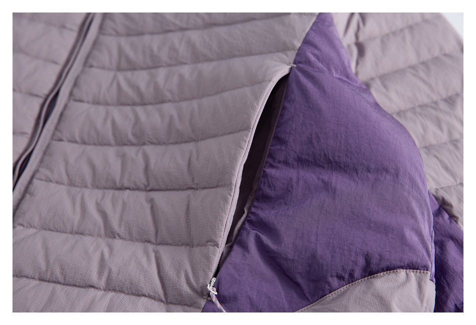Close-up of a zippered opening in the mauve-gray jacket revealing a purple panel.