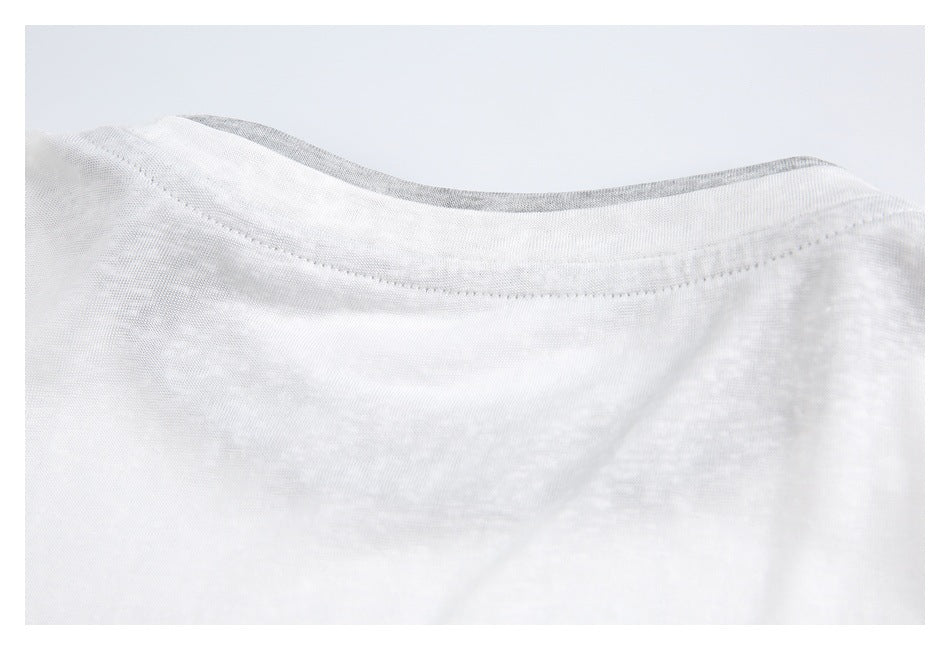 Close-up of a white garment neckline with a curved stitched seam and gray fabric along the inner edge.
