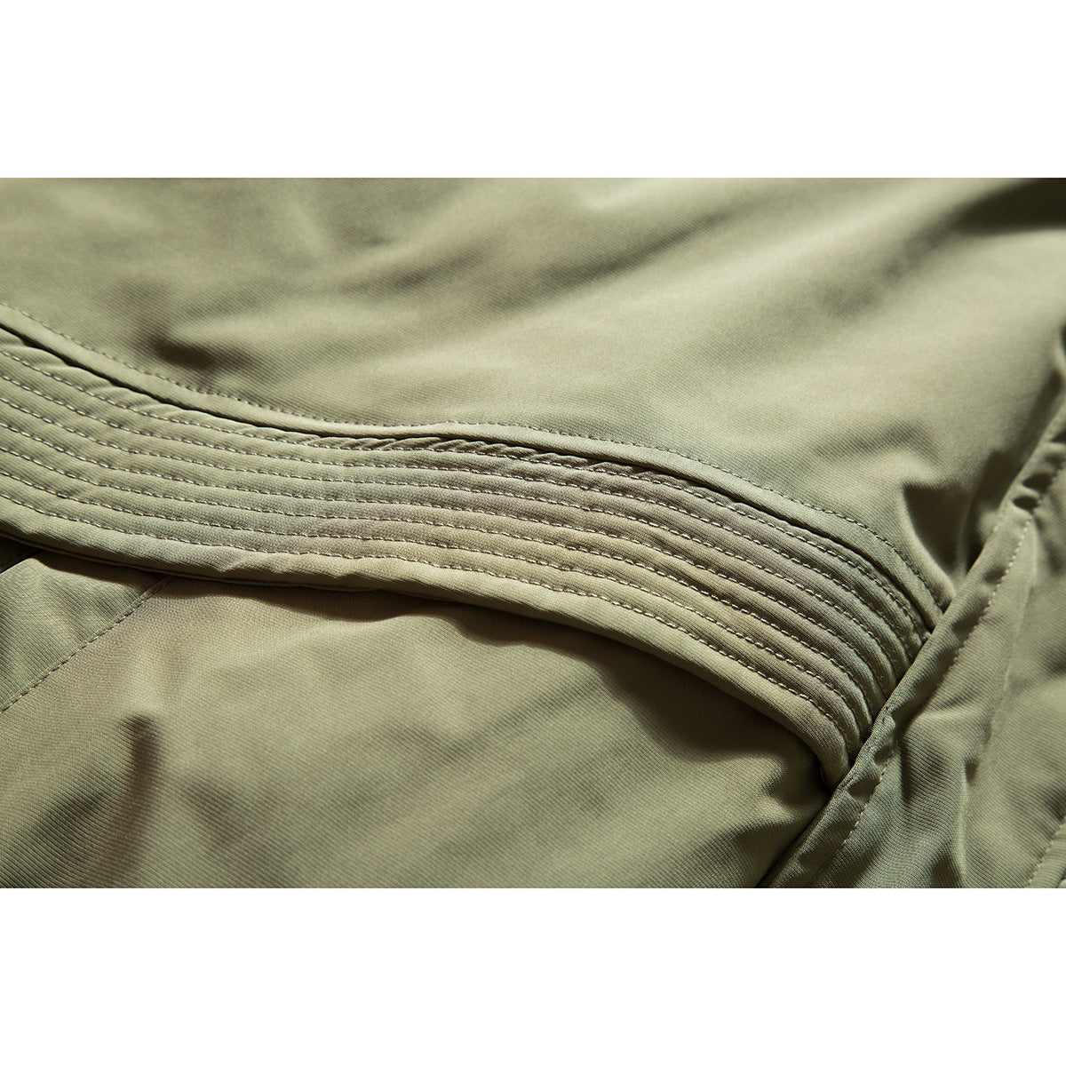 Close-up of multiple rows of stitching on olive khaki jacket fabric.