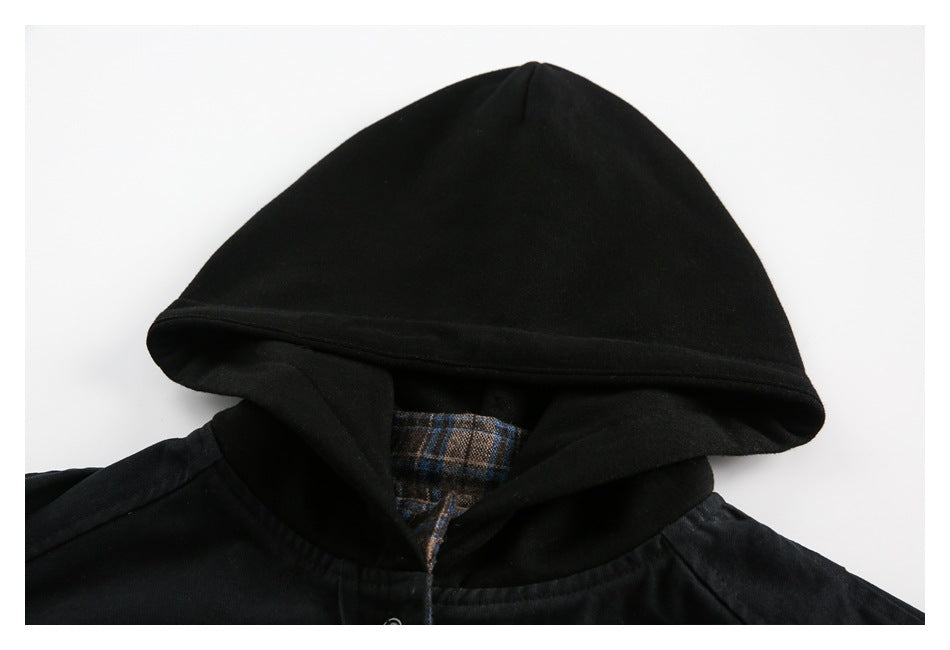 Close-up of a black jacket hood with brown and blue plaid lining at the neckline.