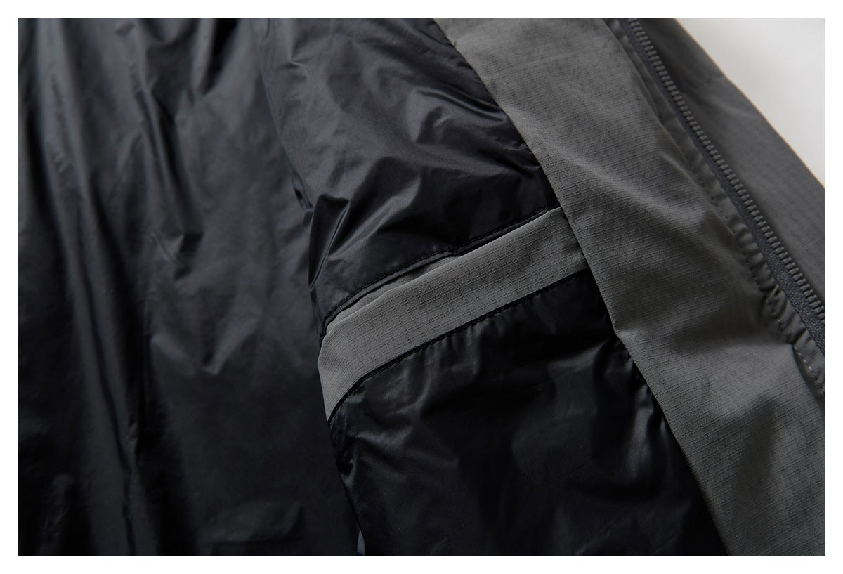 Close-up of a black jacket interior with a gray reinforced strip beside the zipper.