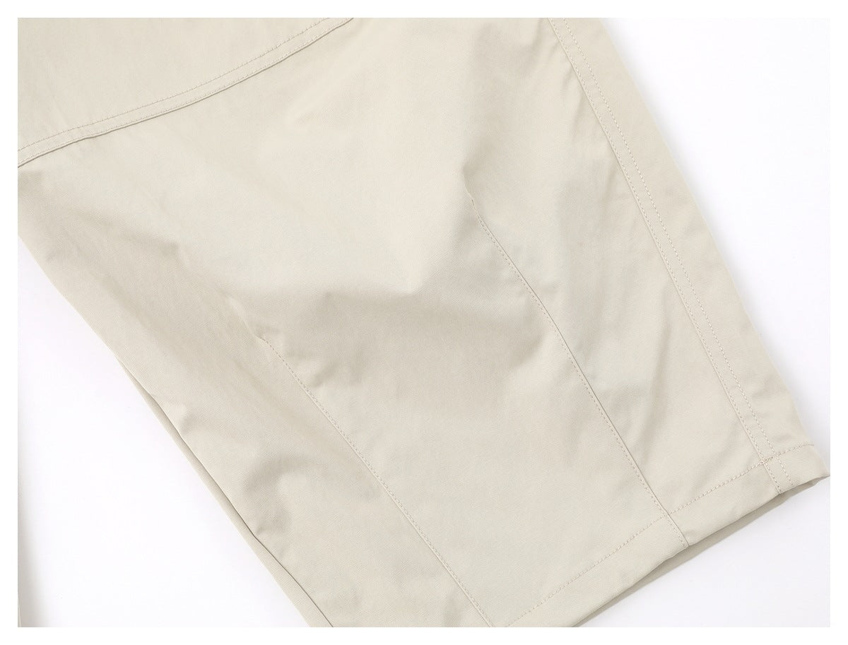 Close-up of the light beige trouser leg, showing panel seams, stitching and the hem.