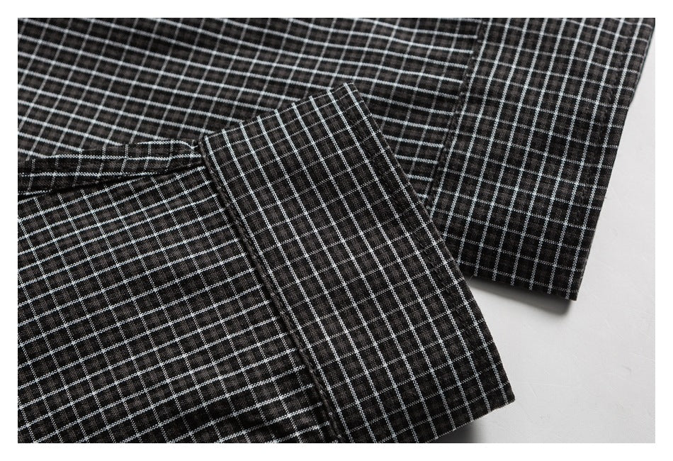 Close-up of a black checked shirt cuff folded over the sleeve.