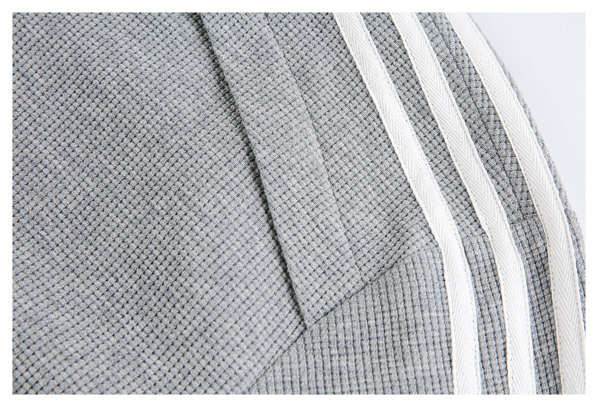 Close-up of the gray jacket's textured shoulder and sleeve with three white stripes.