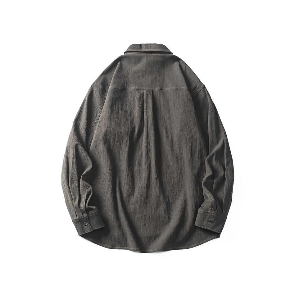 Back view of a charcoal long-sleeve button-up shirt with a yoke seam, pleated back, and button cuffs.