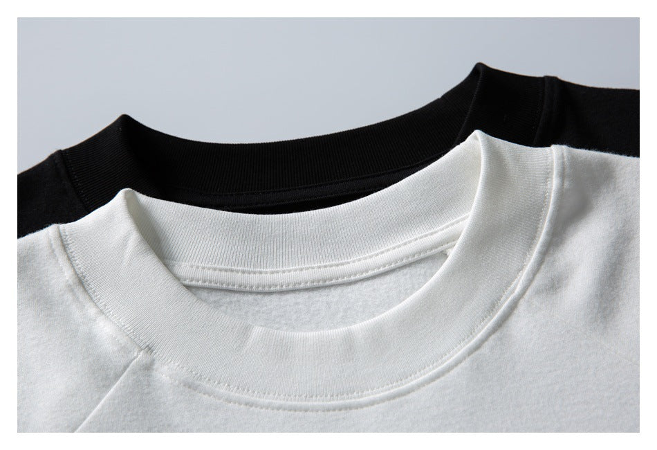 Close-up of a white crew neckline layered over a black crew-neck garment.