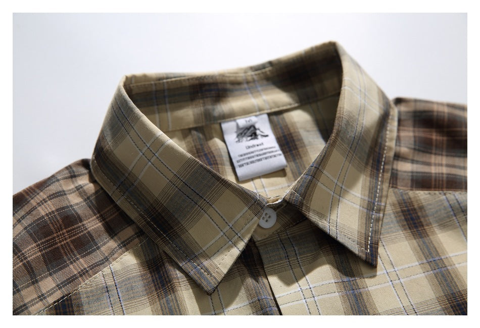 Close-up of the tan and brown plaid shirt collar, button, and inner neck label.