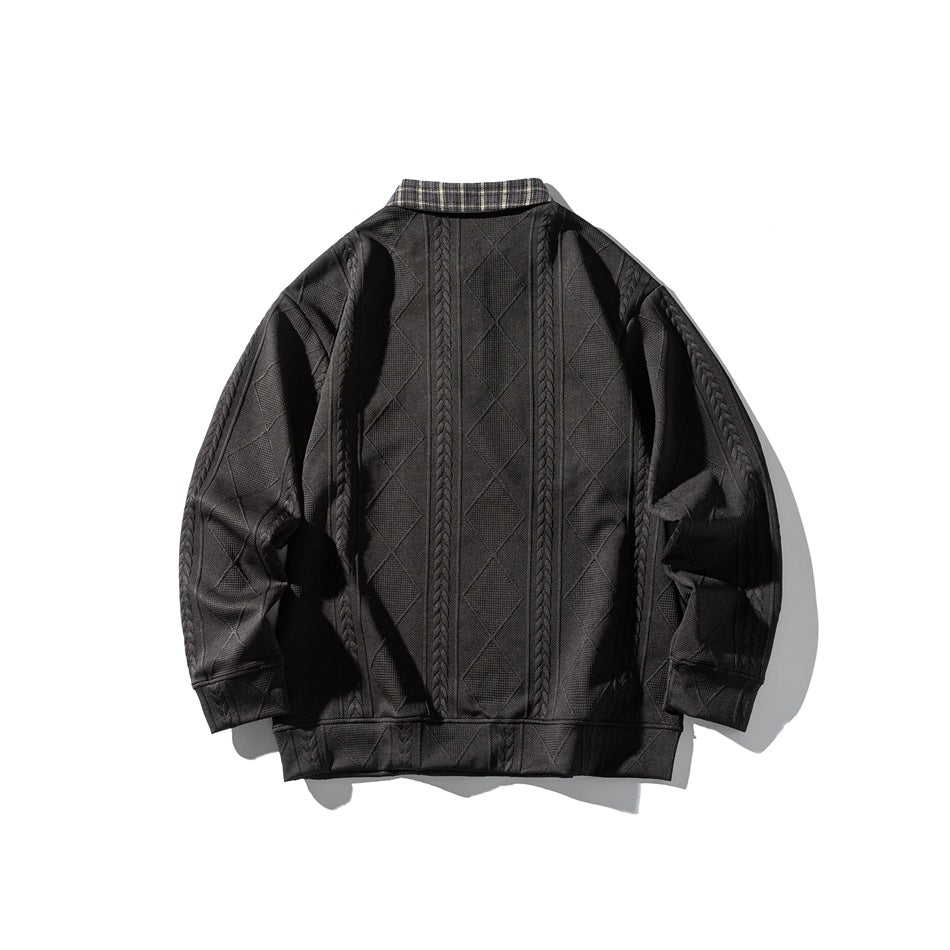 Back of a charcoal sweater with a plaid collar and vertical cable-knit bands over a diamond pattern.