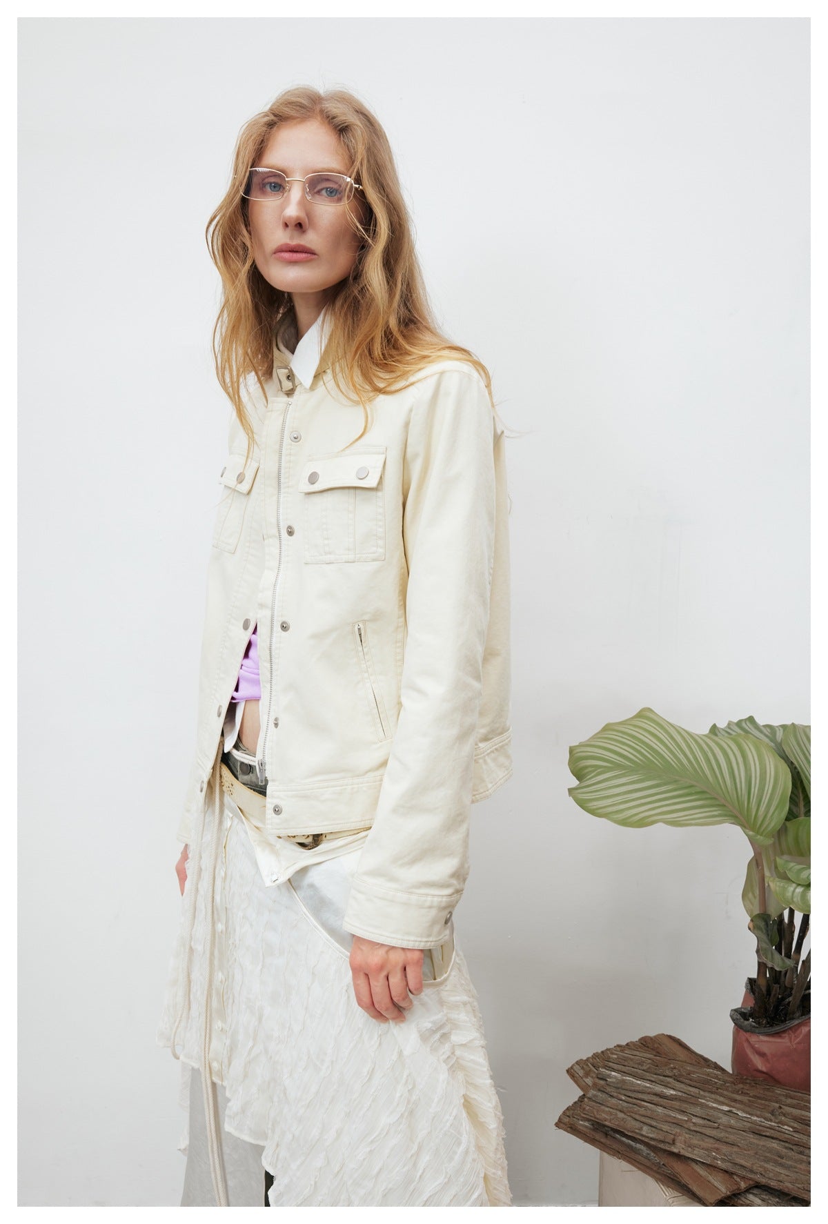 Three-quarter view of a model in an off-white jacket with snap chest pockets, zip pocket and snap cuff