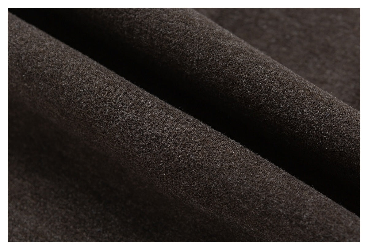 Close-up of dark brown fabric arranged in soft folds, showing its fine textured surface.
