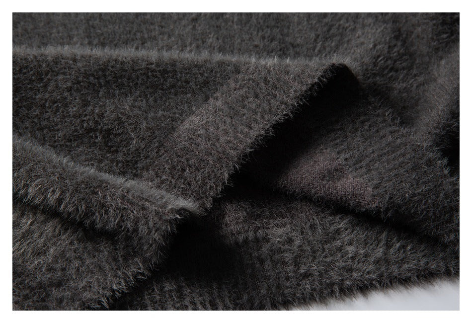 Close-up of overlapping edges in charcoal gray fuzzy knit fabric.