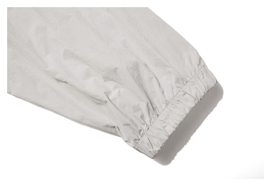 Close-up of a pale gray garment sleeve ending in a gathered elastic cuff.