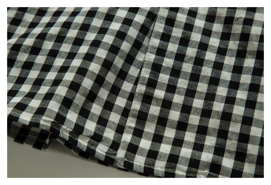 Close-up of black-and-white gingham shirt fabric and a stitched seam near the edge.