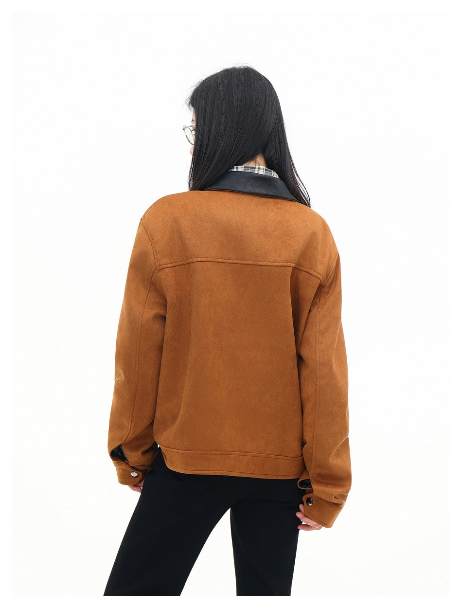 Back view of a model wearing a rust-brown jacket with a black collar and black trousers.