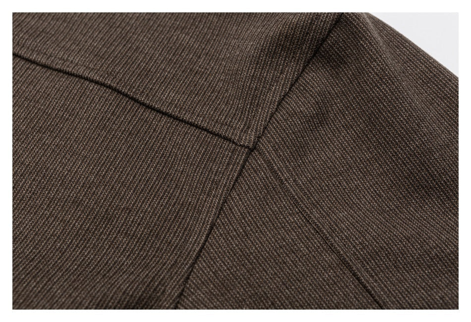Close-up of intersecting seams on a brown textured garment panel.