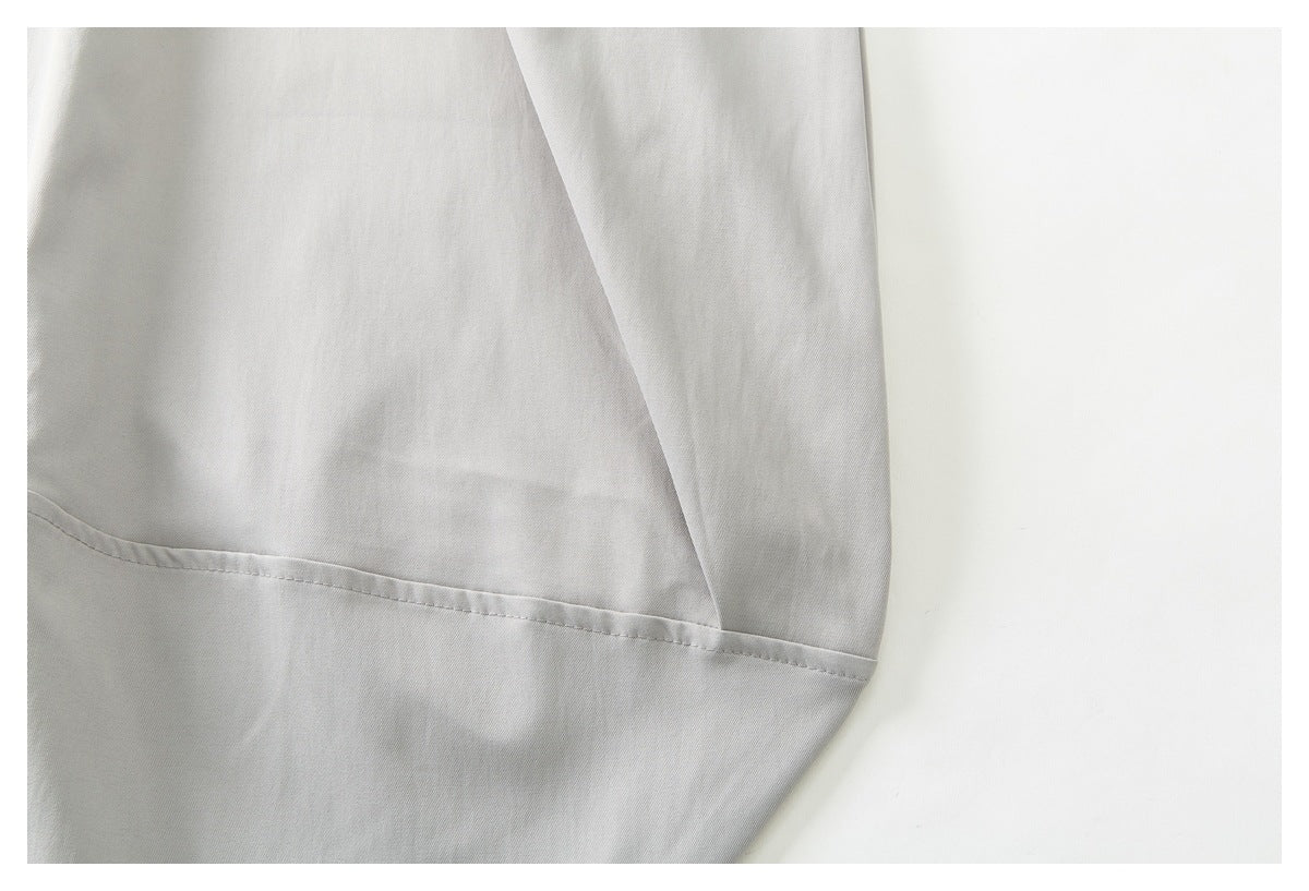Close-up of light gray trouser fabric and a stitched seam near the leg opening.