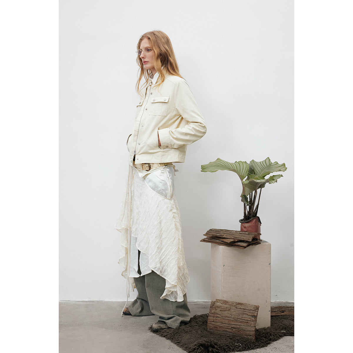 Side view of a model wearing an ivory utility jacket with flap pockets and metal snaps.
