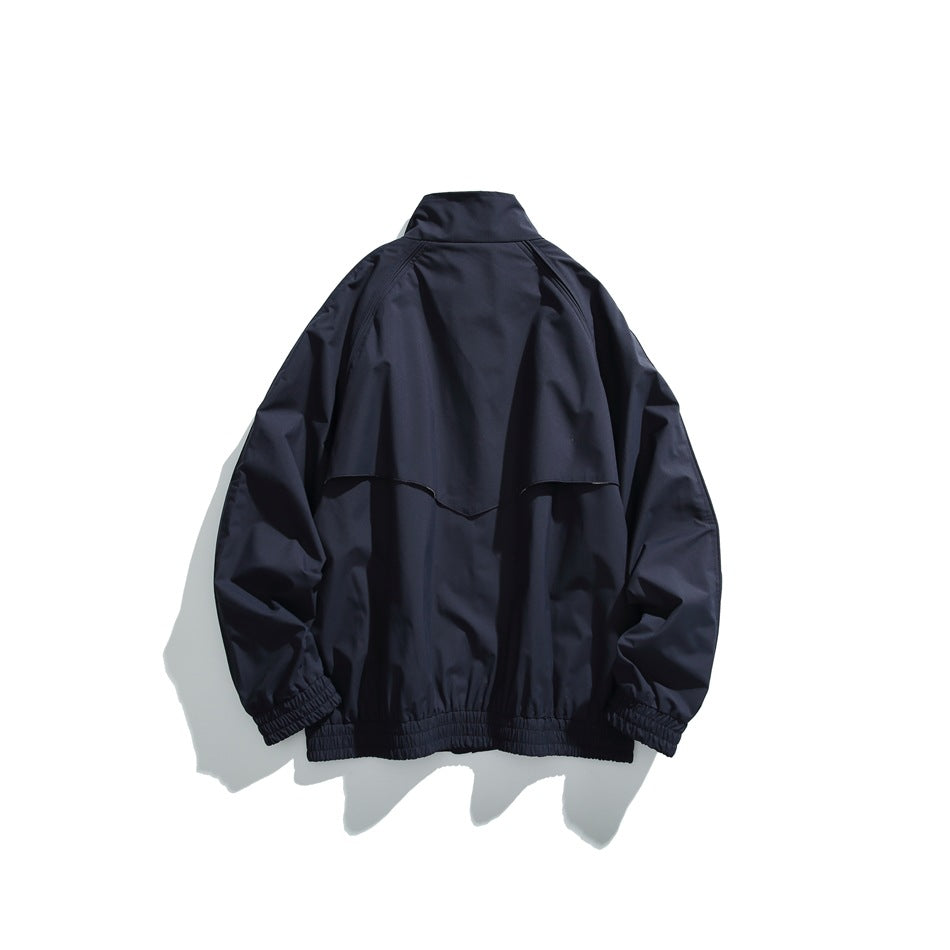 Back view of a dark navy jacket with a back vent, gathered cuffs, and an elastic hem.