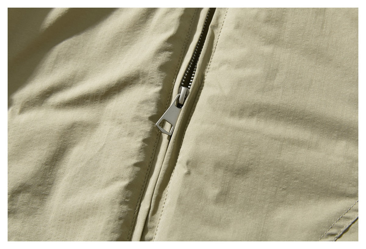 Close-up of the olive-khaki jacket’s front zipper and pull.